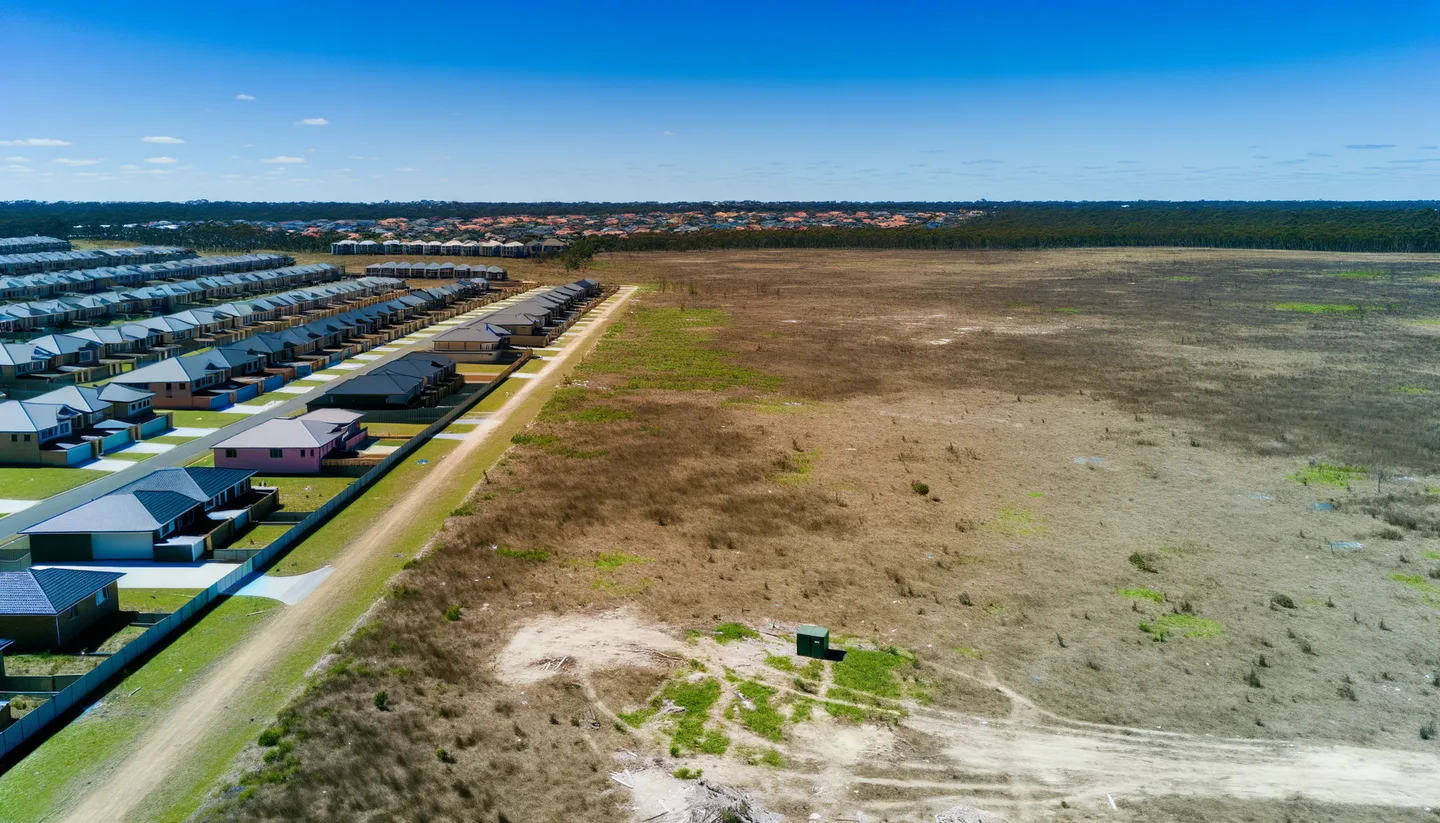 Aerial view of undeveloped land next to new construction